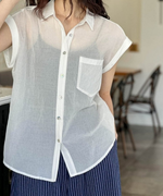 ホワイトのシアーシャツを着用し、ネイビーのストライプパンツを合わせた女性のフロントショット。