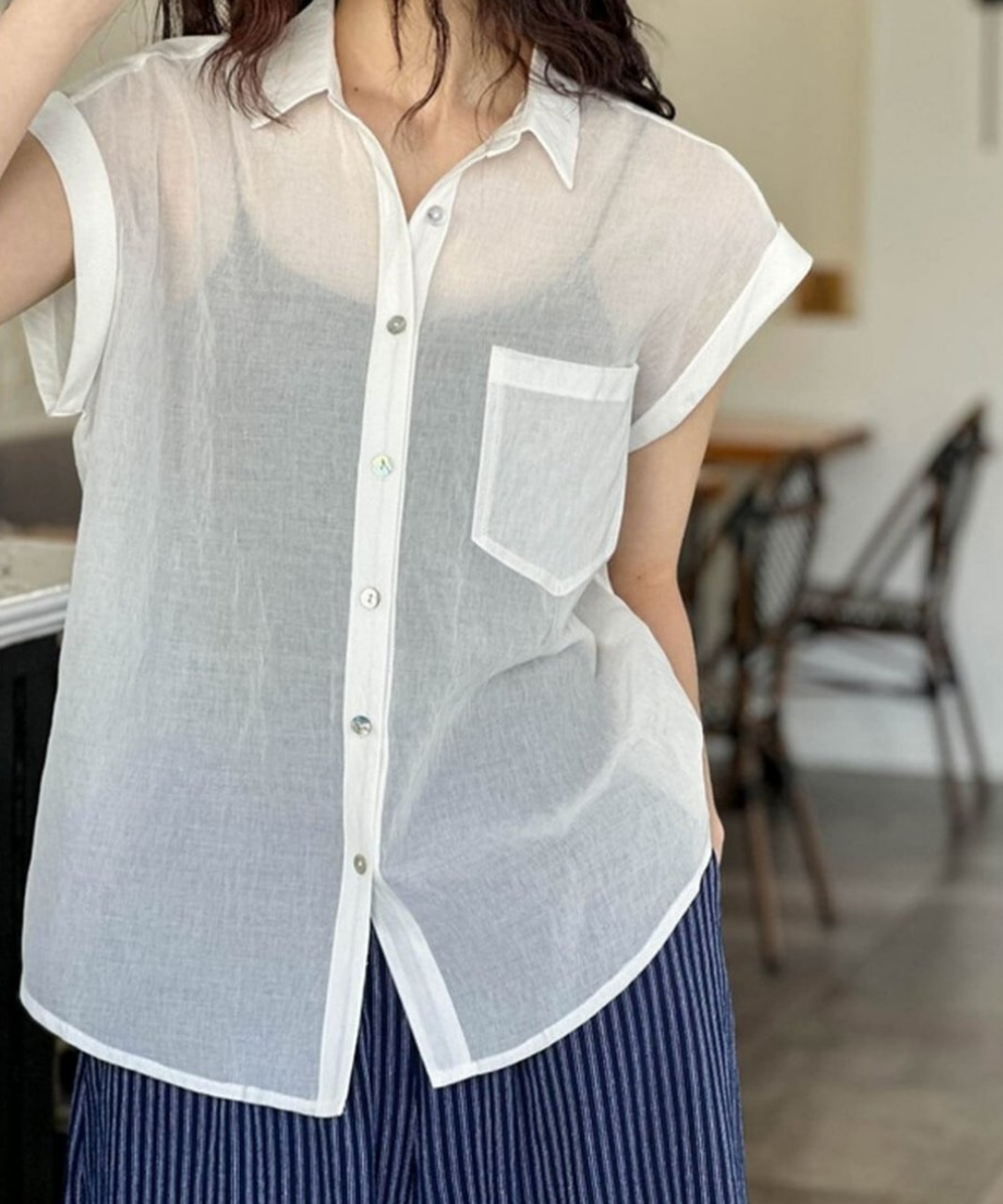 ホワイトのシアーシャツを着用し、ネイビーのストライプパンツを合わせた女性のフロントショット。