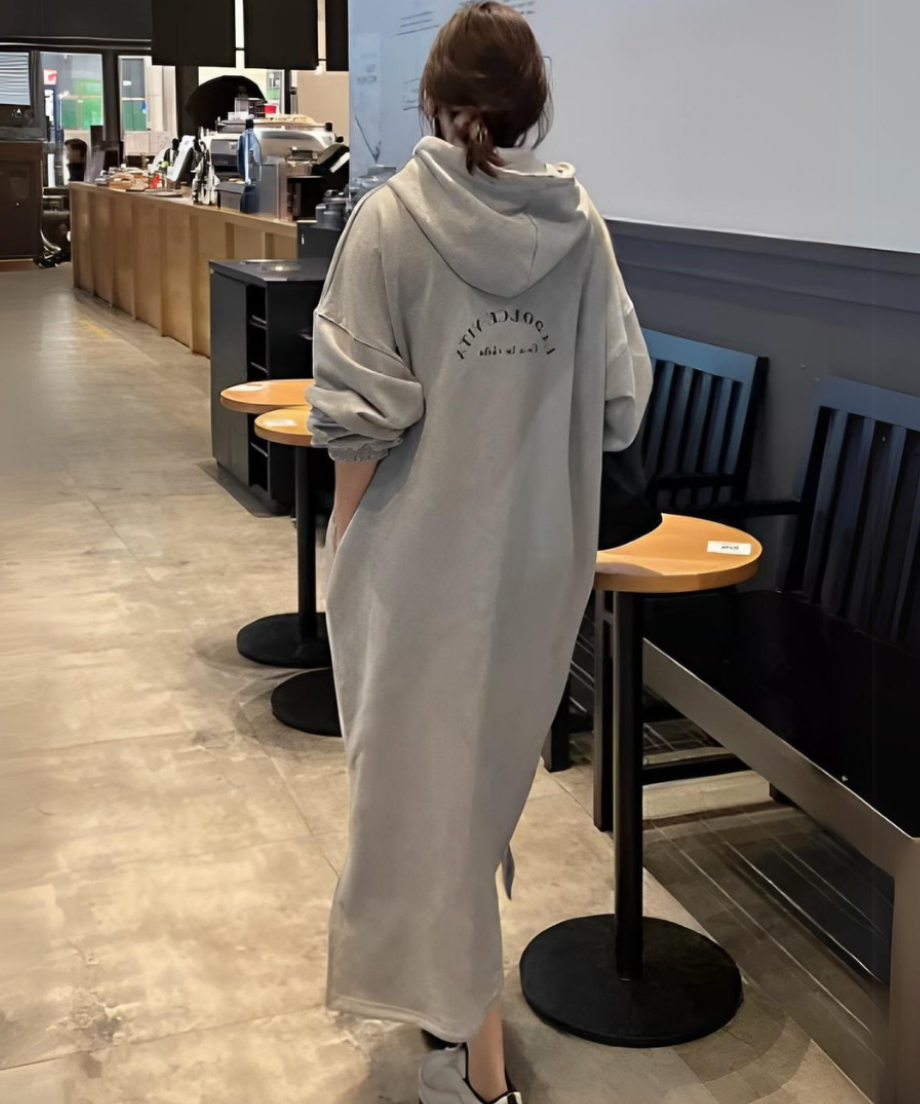 ロング丈フーディワンピースを着た女性の全身。