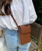 ブラウンフェイクレザーミニショルダーを斜めがけしている女性の後ろ姿。