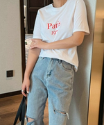 ホワイトのTシャツに赤い「Paris 1970」のロゴが入った、デニムとの爽やかなコーディネート。