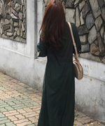 グリーンのロングシャツワンピースを着た女性の後ろ姿。