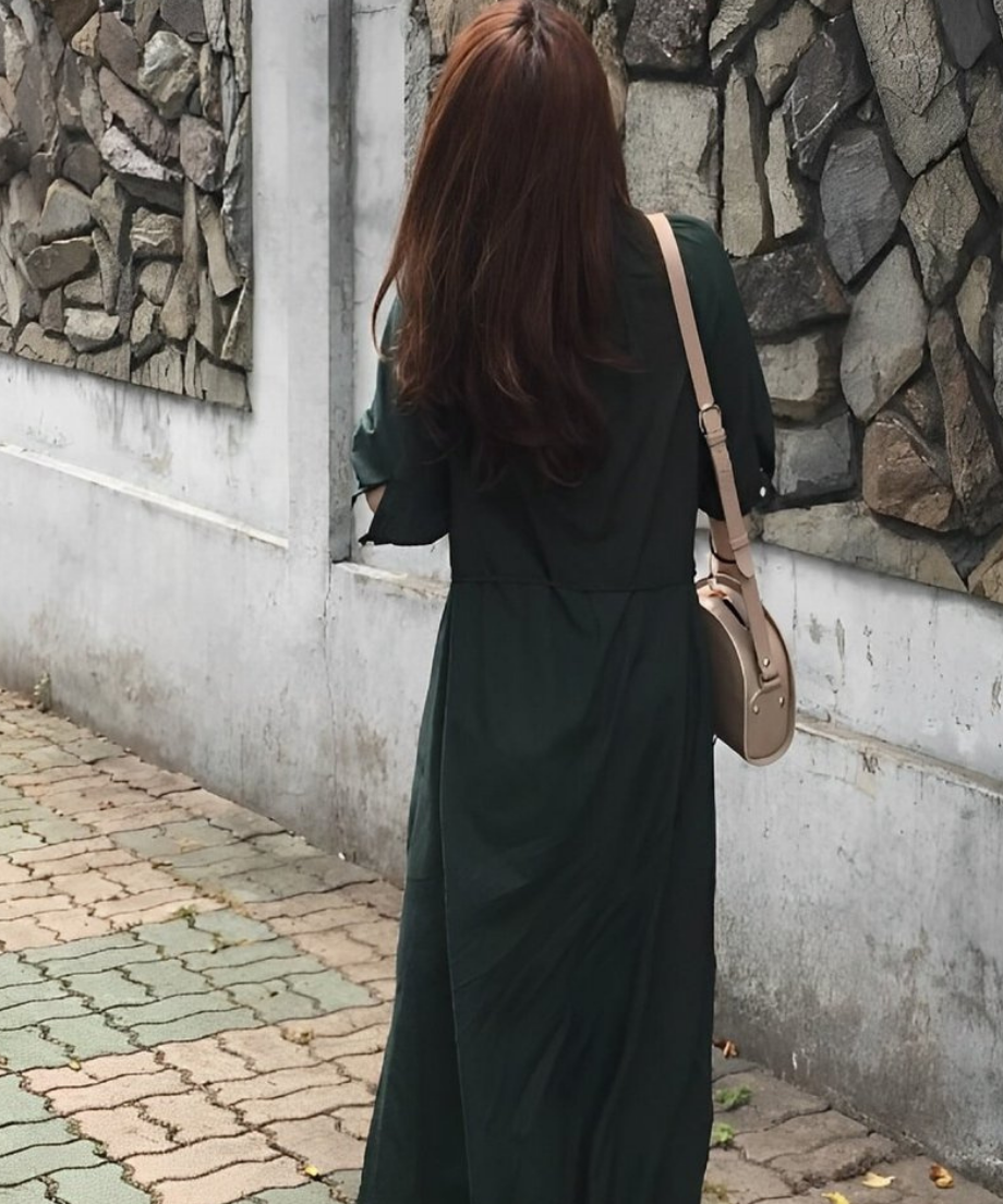 グリーンのロングシャツワンピースを着た女性の後ろ姿。