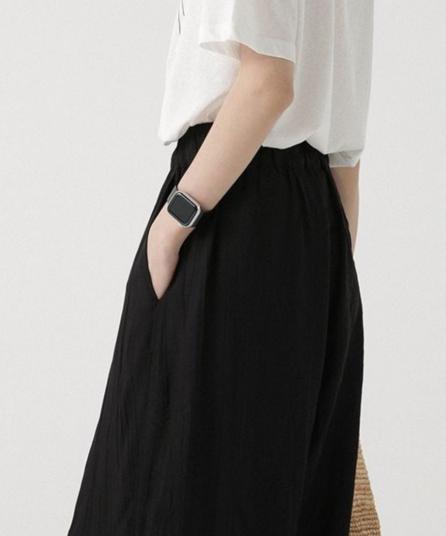 ブラックのワイドパンツに白いプリントTシャツを合わせたサイドスタイルのアップ。
