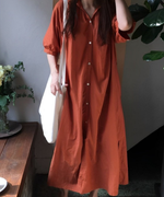 オレンジブラウンのVネックロングシャツワンピースを着た女性の全身。
