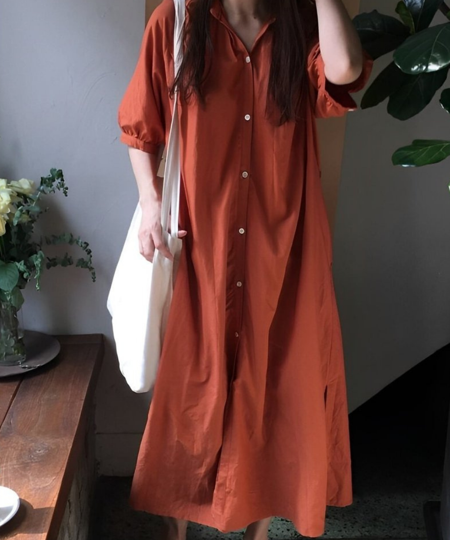オレンジブラウンのVネックロングシャツワンピースを着た女性の全身。