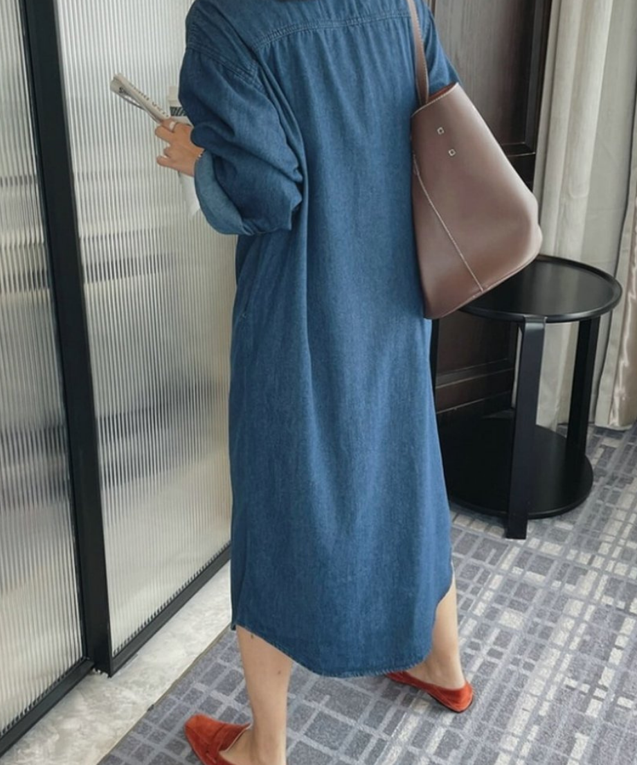 デニムシャツワンピースを着用した女性のバックスタイル。足元は鮮やかなオレンジのローファー