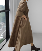 カーキのフレアワンピースに黒のショートブーツを合わせた落ち着いたコーディネート。