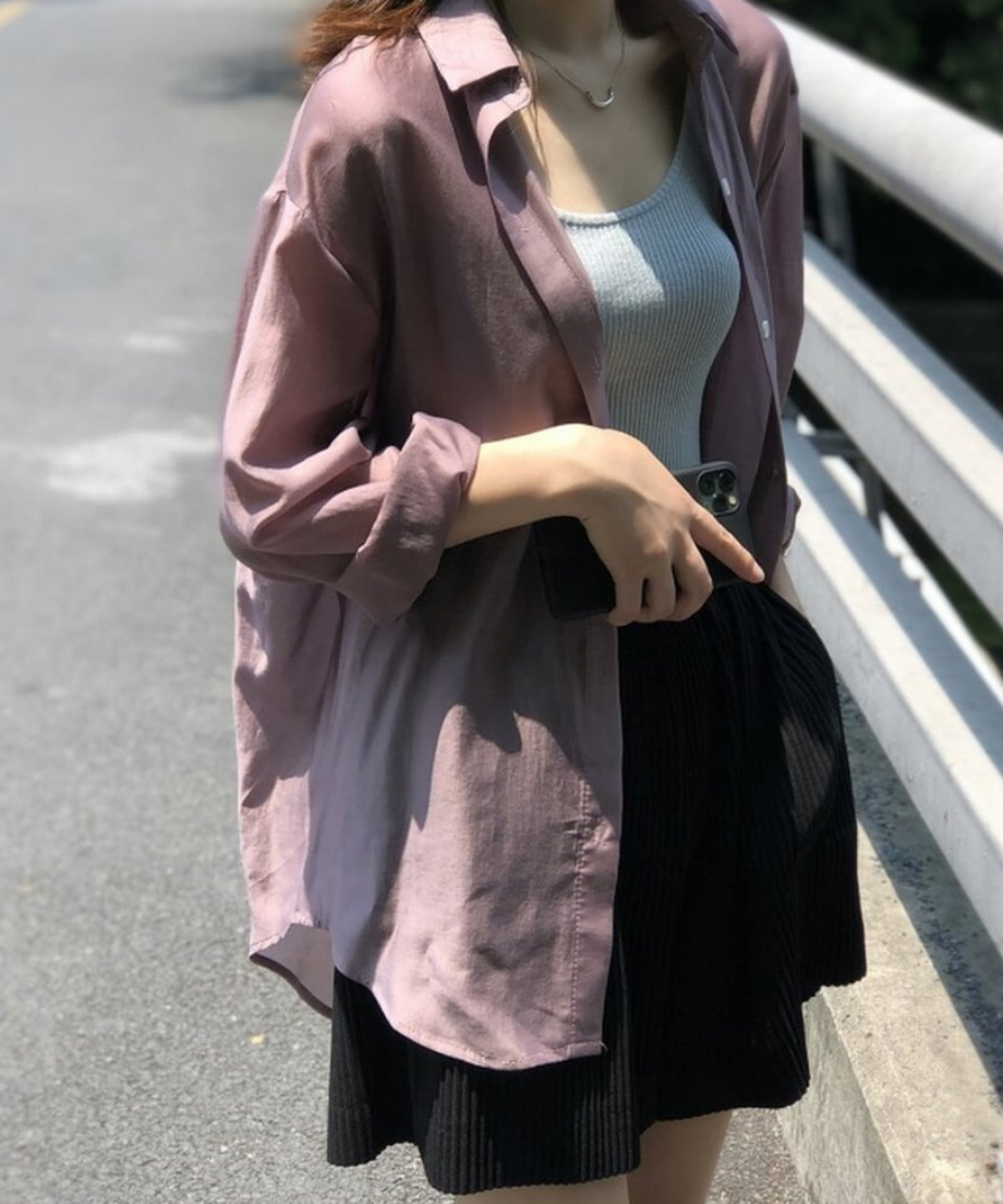 屋外でピンクのシアーシャツを着用している女性。