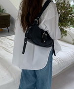 白のシャツとゆったりしたデニムパンツに、黒のショルダーバッグを合わせたリラックス感のあるバックスタイル