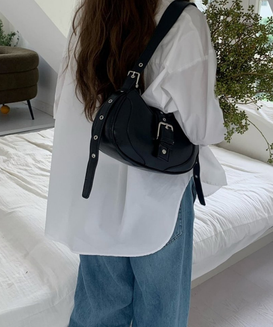 白のシャツとゆったりしたデニムパンツに、黒のショルダーバッグを合わせたリラックス感のあるバックスタイル