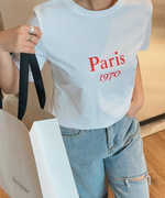 ホワイトのTシャツに大きなショッパーを合わせた、ショッピングシーンをイメージさせるスタイル。