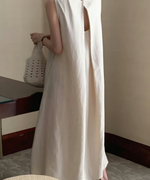 背面が大きく開いたオフホワイトのマキシワンピースを着た女性の後ろ姿