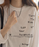 白のメッセージプリントロングTシャツのアップショット。英字で書かれた文字が見える。
