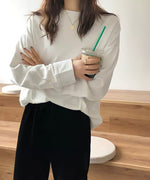 白のオーバーサイズ長袖Tシャツ（カットソー）を着用した女性のアップ。