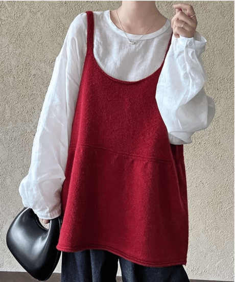 白のインナーにバーガンディーのチュニックトップスを合わせた女性