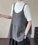 黒のハイネックカットソーにアイボリーのウール混チュニックトップスを重ねた女性