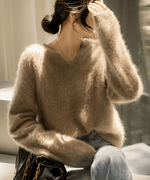 アプリコットのセーターを着た女性が顔を隠しているシーン。