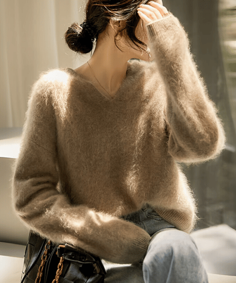 アプリコットのセーターを着た女性が顔を隠しているシーン。