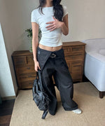 ホワイトTシャツとブラックのワイドパンツを合わせ、黒いバッグを持った女性。