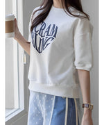 白いTシャツを着た女性が窓際でリラックスしている様子。