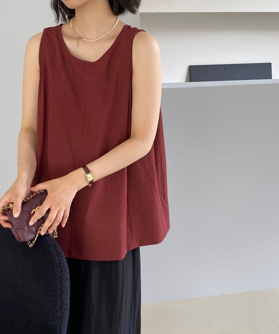 レトロレッドのブラウスを着た女性のフロントスタイル。黒のワイドパンツを合わせている。