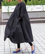 ブラックカラーのロングワンピースを着た女性の横から見たスタイル。