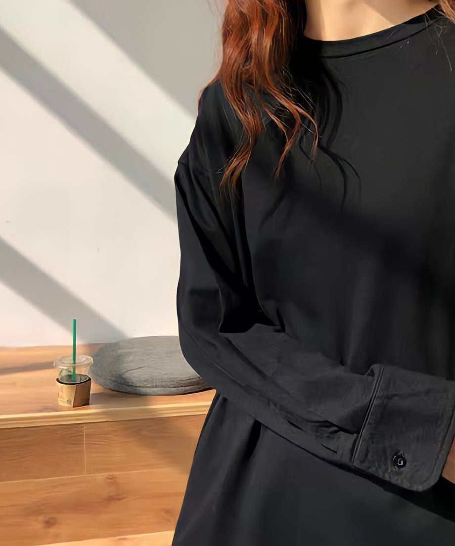 黒のオーバーサイズ長袖Tシャツ（カットソー）を着用した女性のアップ。