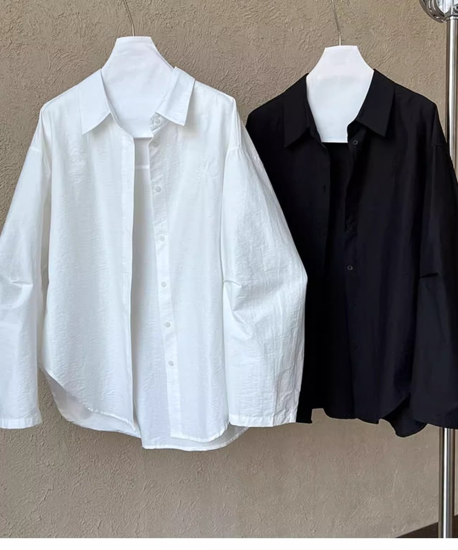 黒と白のシャツがハンガーにかけられた画像。