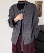 グレーのウールショートコートを着用した女性。コートのベルトを長く垂らして、黒のタートルネックとワインレッドのパンツを合わせている。