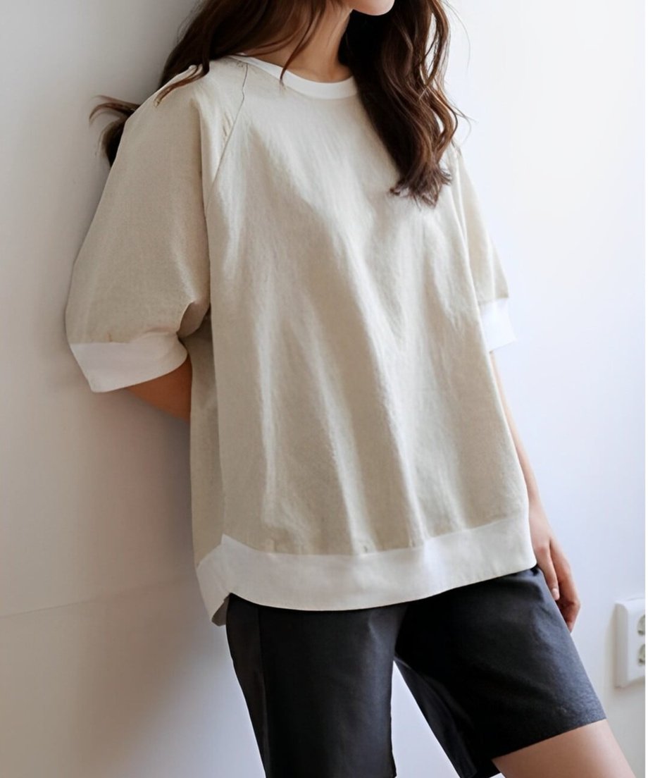 ベージュのトップスを着た女性の横向きの上半身。