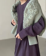 グリーンのフローラル刺繍セーターを肩にかけた女性、パープルのワンピースとコーディネート。