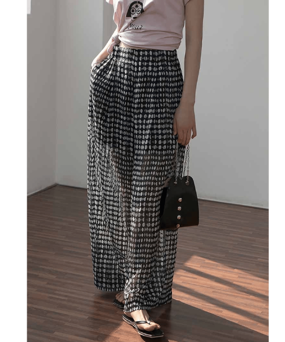 ピンクのグラフィックTシャツをウエストで結び、ハイウエストドット柄ワイドパンツを合わせた、リラックス感のある夏のレディースコーディネート。