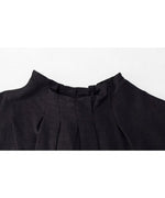 黒のトップスの裾の生地感のクローズアップ。