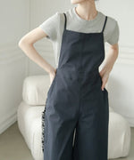 スクエアネックの黒いサロペットの胸元と、グレーのTシャツを合わせたレイヤードスタイルのアップ写真。