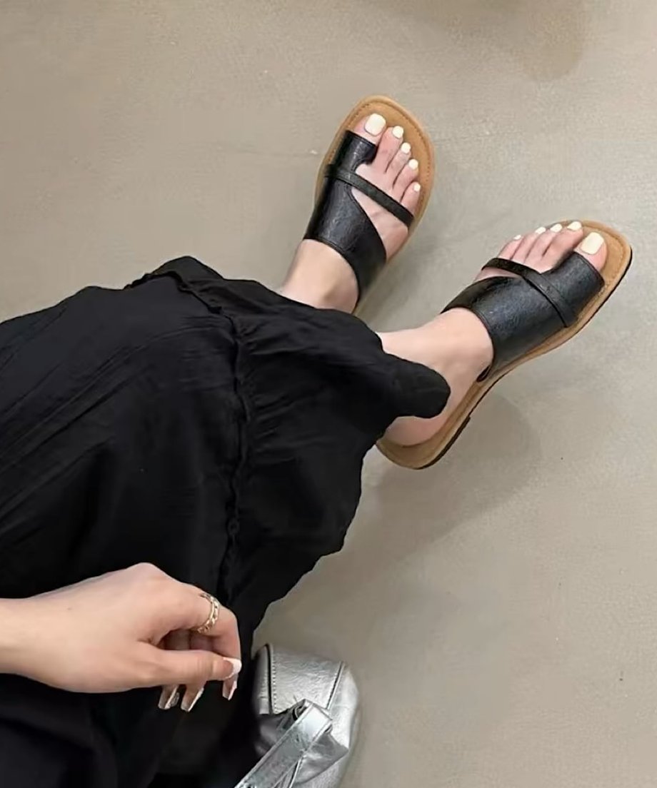 黒のロングスカートにブラックのサムループサンダルを合わせた足元のコーディネート