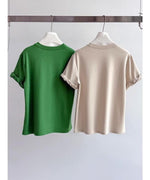 グリーンとベージュの2色のロールアップスリーブTシャツがハンガーに掛けられている写真