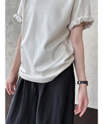 ベージュのTシャツの袖ロールアップ部分を強調したアップ写真