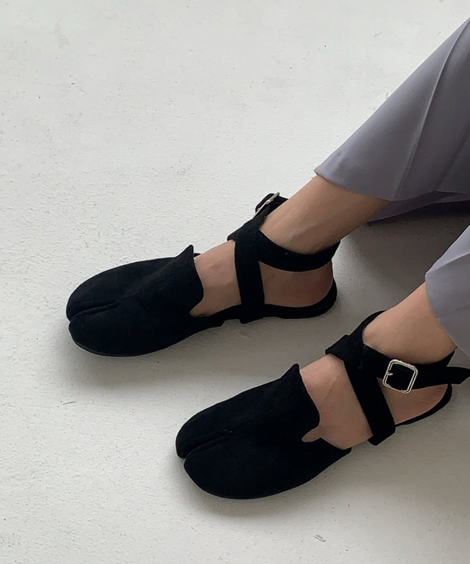 グレーのボトムスで、足元にブラックのタビサンダルを合わせたモードなコーディネート。