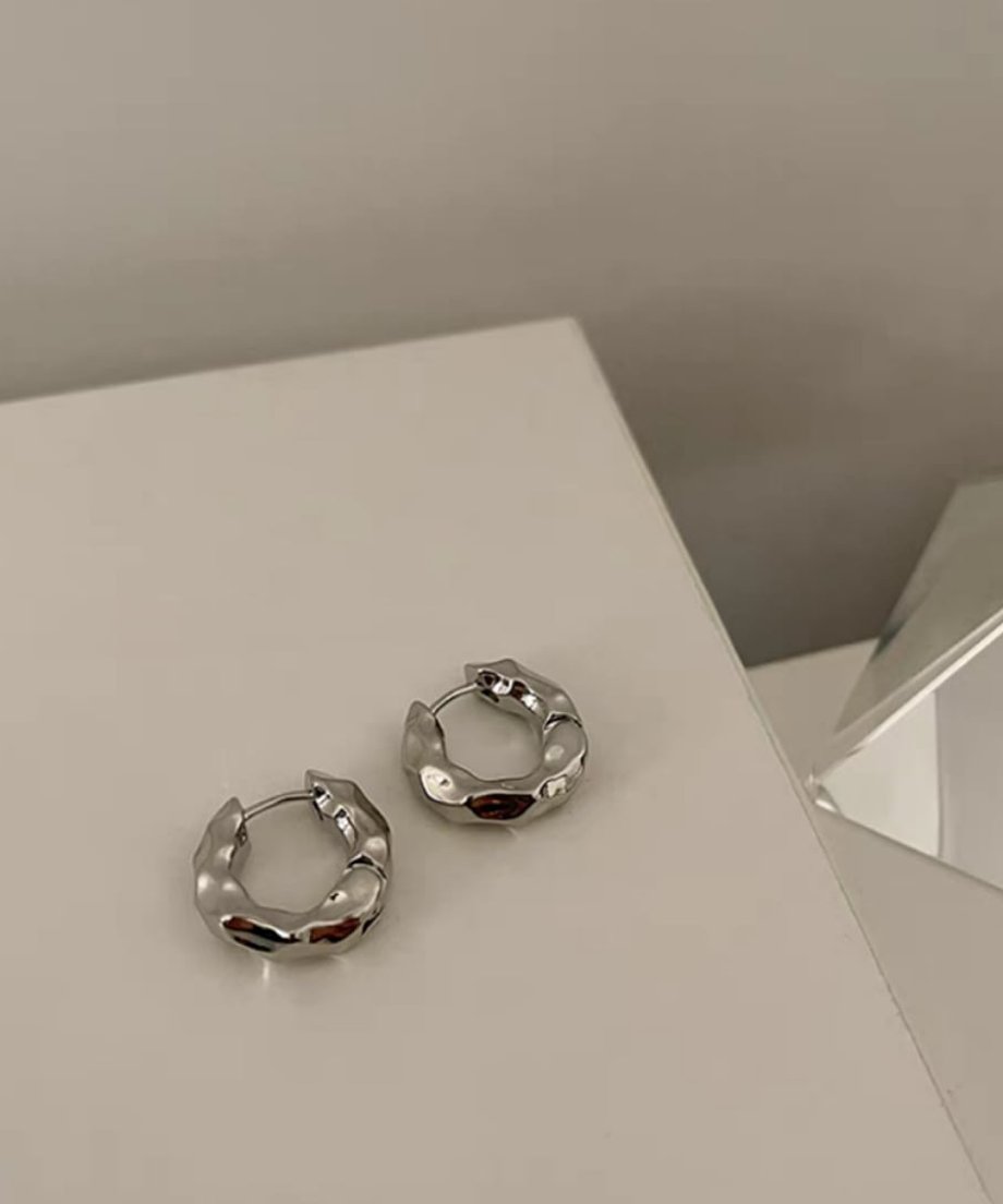 シルバーのペアピアス。表面の不規則な凹凸が強調された、モダンでスタイリッシュなデザイン。