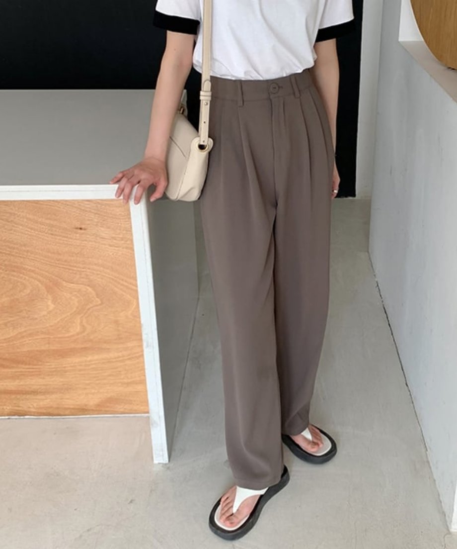 ブラウンのタックパンツに白いTシャツとトングサンダルを合わせた、リラックス感のある夏の着こなし。
