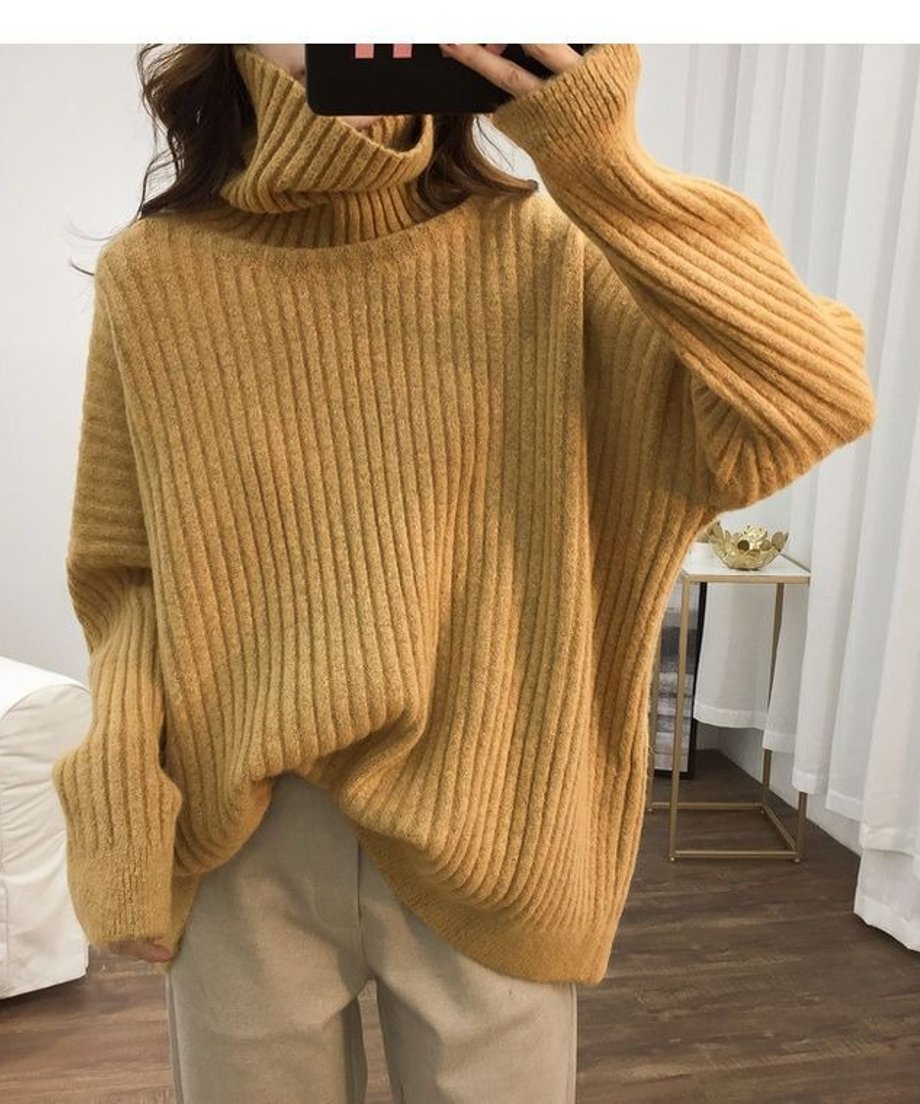 イエローのオーバーサイズタートルネックニットを着用した女性の上半身。ゆったりとした袖とリブ編みのディテールが見える。