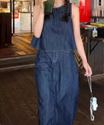 ドリンクを手に持ち、動きのあるポーズでデニムスリーブレスセットアップのシルエットを捉えたカット。