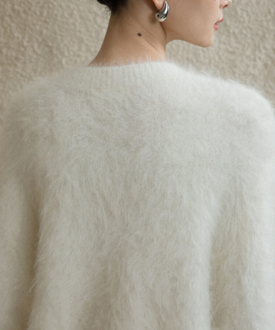 ホワイトのふわふわニットを着用した女性の後ろ姿。