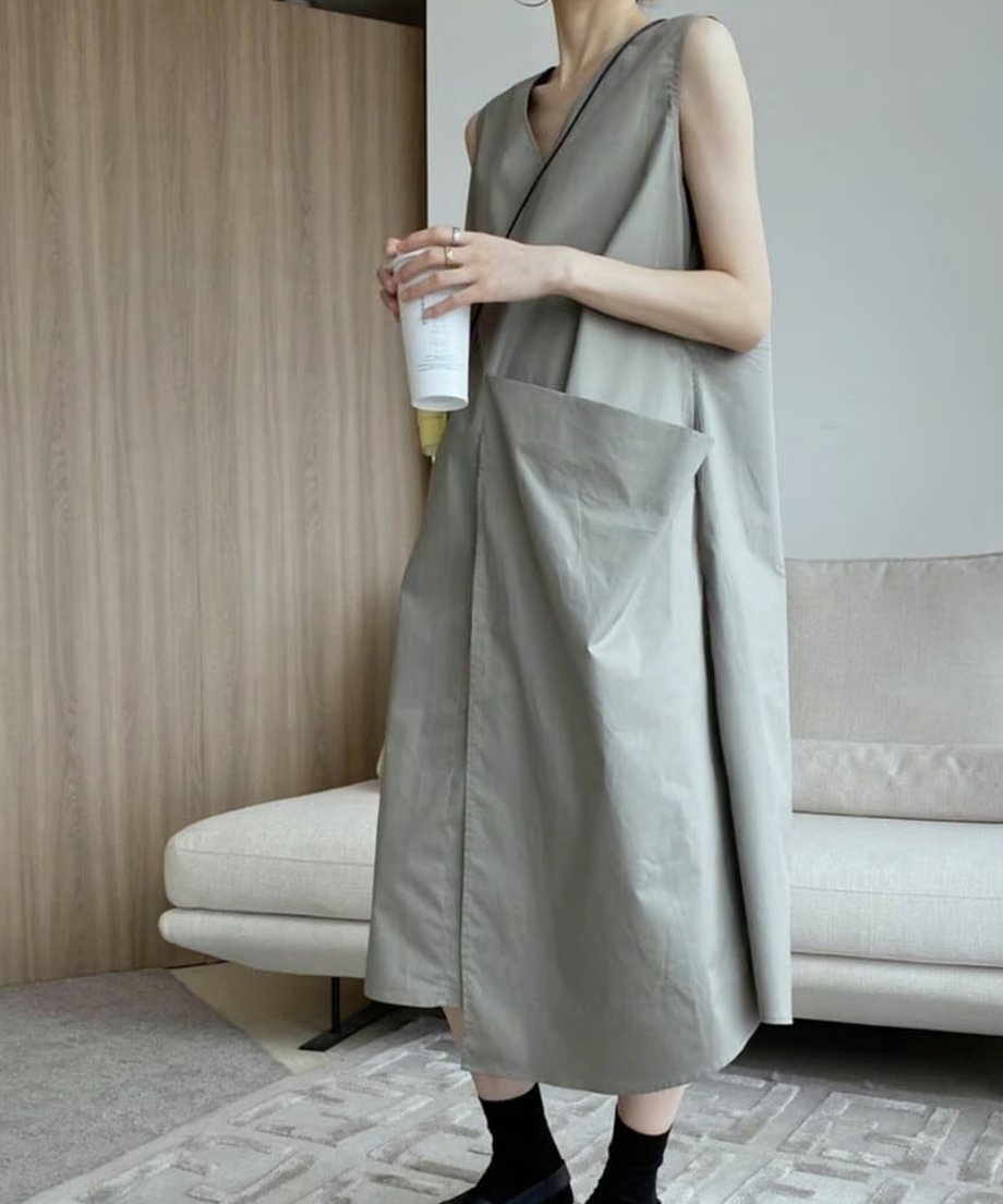 Vネックを前にして着用したグレーのアシンメトリーワンピース。ゆったりとしたシルエット。