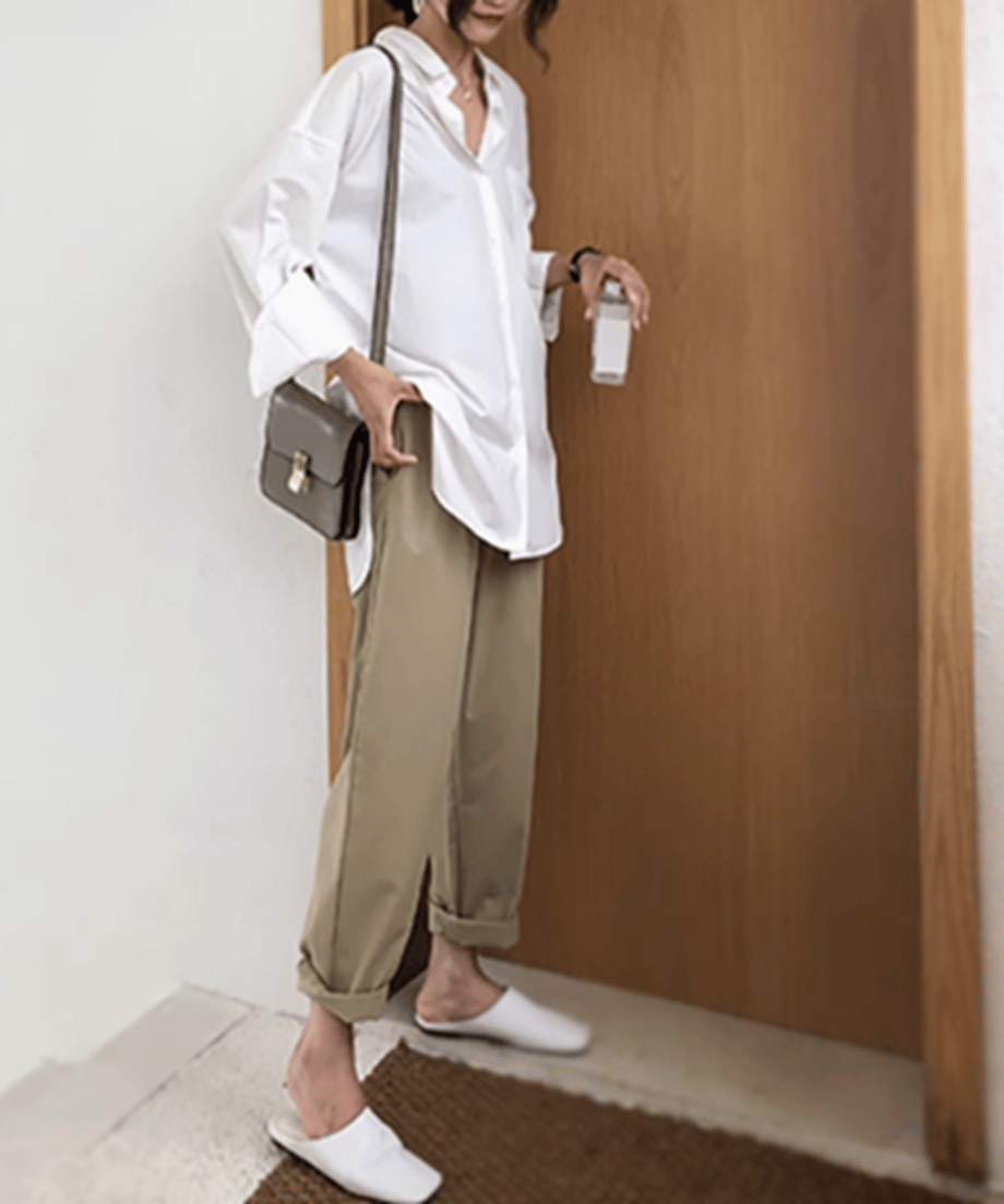 ホワイトシャツとベージュパンツのコーディネートをした女性。