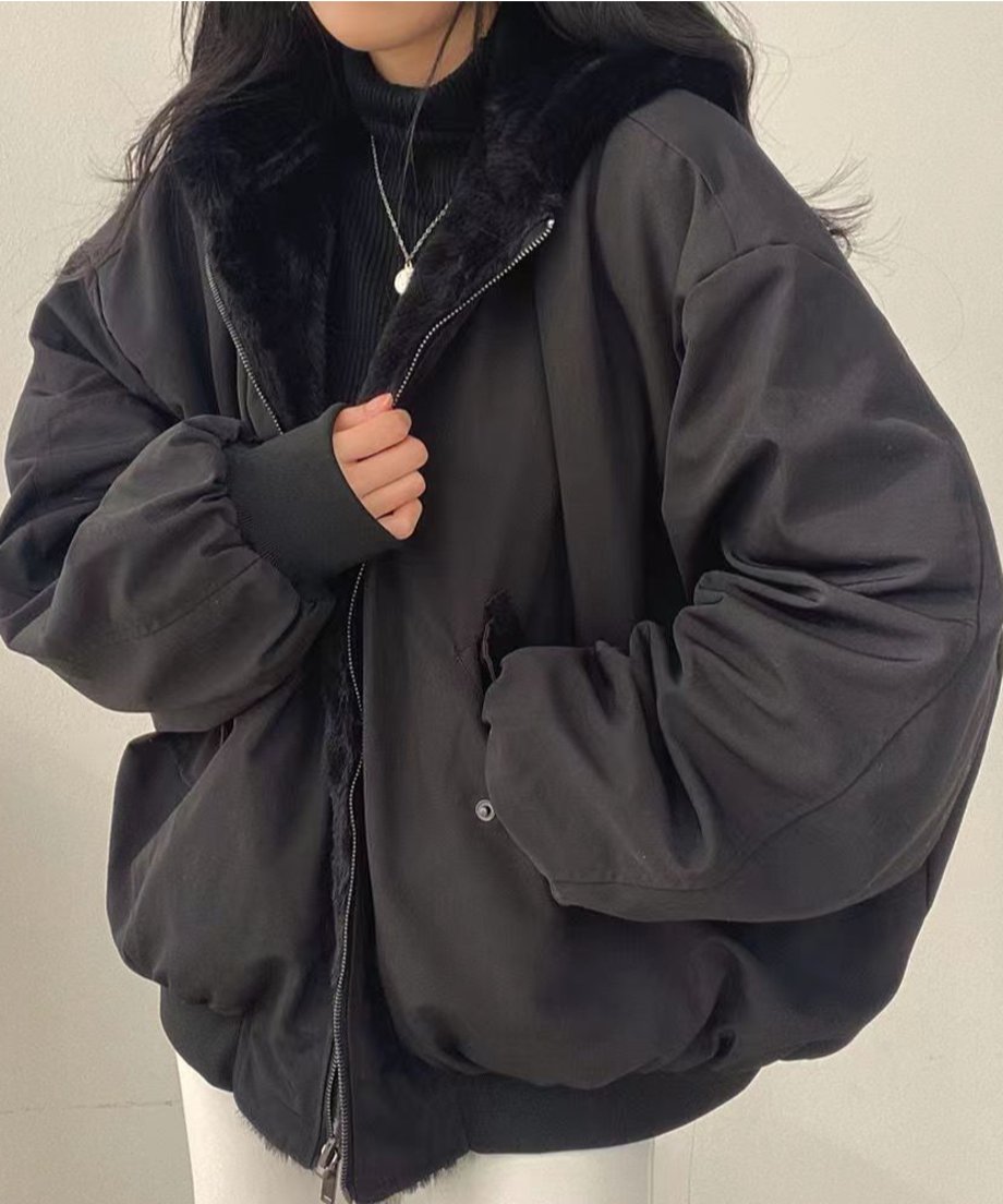 女性が黒いタートルネックニットの上にブラックのボアブルゾンを羽織ている写真。袖