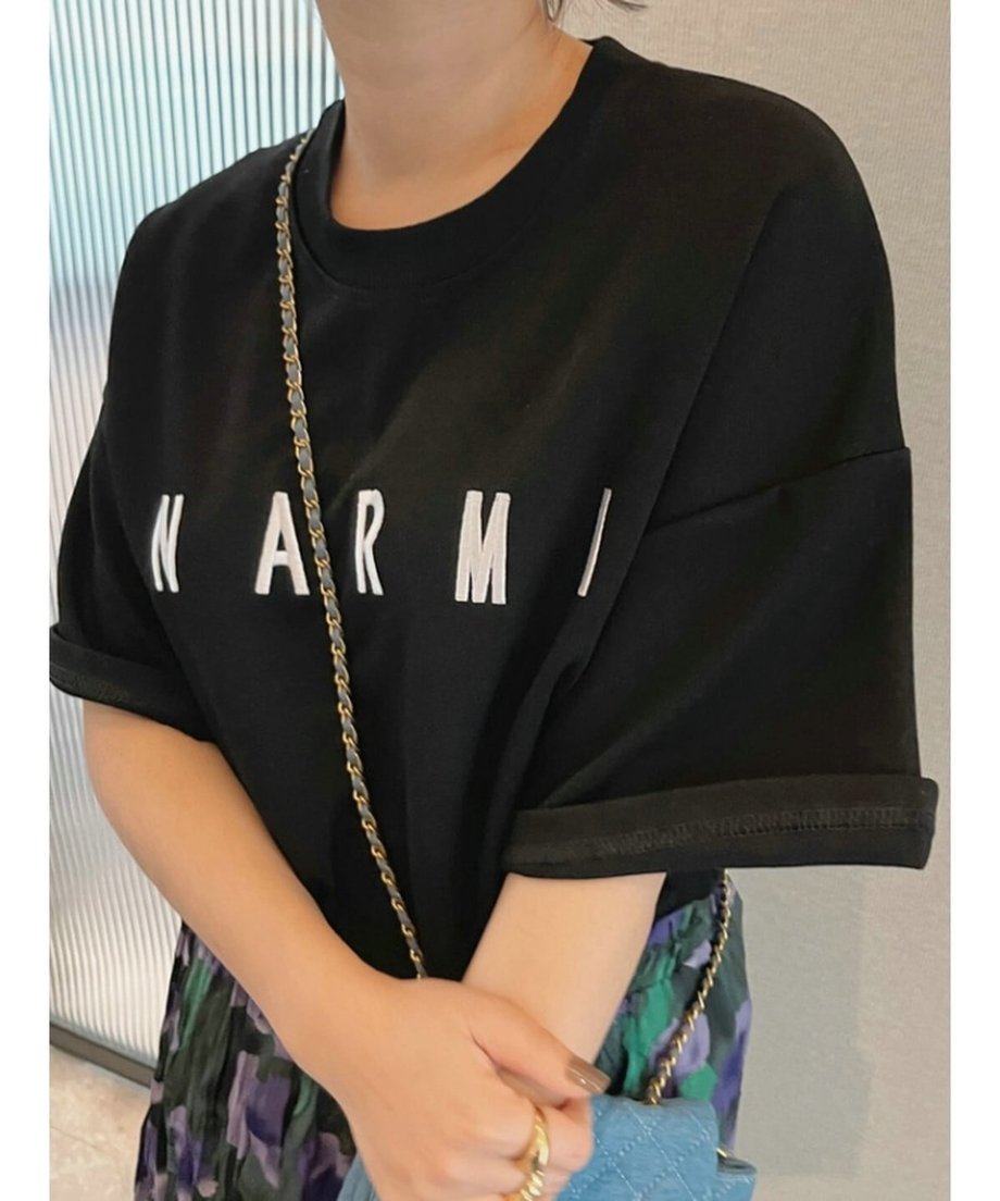 ブラックのTシャツの袖口をロールアップし、立体ロゴを強調したニュアンスのある着用カット。