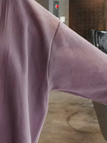 ピンクのオーバーサイズスウェットシャツ袖部分の素材感を撮影した画像。