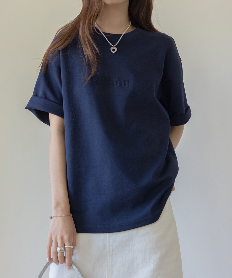 ネイビーのTシャツとホワイトスカートを組み合わせたカジュアルでシックな装い。